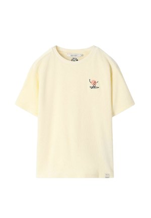 T-shirt en tissu éponge de couleur crème, manches courtes, avec une petite figure de soleil souriant brodée sur le côté gauche de la poitrine et un col rond.