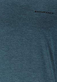 Dunkelblaues Sport-T-Shirt aus einem strukturierten, atmungsaktiven Stoff. Verfügt über ein kleines "ENDURANCE"-Logo in Schwarz. Leicht und feuchtigkeitsableitend.