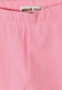 Ceinture élastique rose d'un pantalon pour enfants avec une étiquette de taille visible indiquant 5-6 ans, 110-116 cm, fabriqué au Bangladesh.