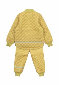Gelbe gesteppte Jacke und Hose, die ein Rautenmuster, gerippte Bündchen, einen reflektierenden Streifen und einen runden Kragen aufweisen.