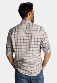 Crème flanellen shirt met een blauw ruitpatroon, lange mouwen opgerold, achterkantzicht, met een schouderstuk en een relaxte pasvorm.