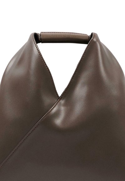 Sac à main en cuir lisse marron foncé avec une forme triangulaire douce et une poignée courte arrondie au centre du dessus.