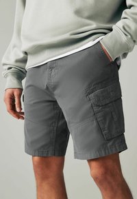 Grau Cargo-Shorts mit mehreren Taschen, aus strapazierfähigem Material gefertigt. Mit gesteppten Nähten, lockerer Passform und einem Saum über dem Knie.