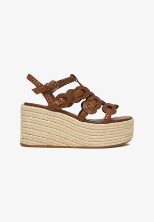 Sandalia cuña de cuero trenzado marrón con correa en el tobillo y suela plataforma de cuerda beige gruesa.