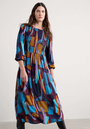 Midikleid in lebhaftem Blau, Lila und orangefarbenen Mustern. Mit einem gerafften Oberteil und ausgestellten Ärmeln. Aus weichem Stoff gefertigt.