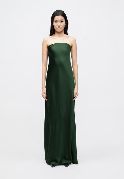 Abito lungo senza spalline in raso verde scuro, caratterizzato da una vestibilità aderente e una texture liscia con una sottile lucentezza. Design semplice e minimalista.