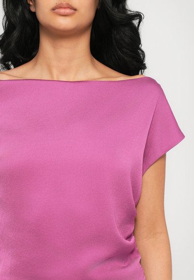 T-shirt à manches courtes en tissu rose vif, avec un décolleté hors-épaule et une texture lisse. Design simple sans motifs visibles.