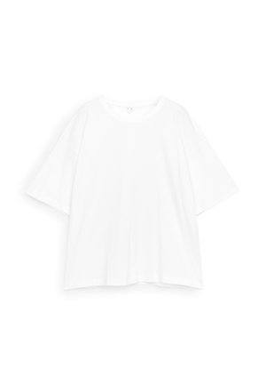 T-shirt blanc surdimensionné à manches courtes avec encolure ronde, présenté à plat sur un fond blanc.