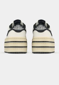 Λευκά δερμάτινα αθλητικά παπούτσια με παχύ στρωματοποιημένο πάτο σε μπεζ και μαύρο χρώμα. Διαθέτουν μαύρες λεπτομέρειες και κεντημένο λογότυπο στην πίσω επένδυση του αστραγάλου.