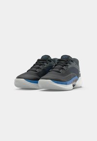 Des chaussures de sport noires avec des accents bleus. Elles présentent un dessus texturé, une languette rembourrée, et une semelle en caoutchouc blanche avec une bande bleue. Design léger.