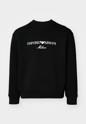 Felpa nera realizzata in tessuto misto cotone; presenta un colletto tondo e polsini a costine. Il logo bianco visibile riporta la scritta "EMPORIO ARMANI Milano."