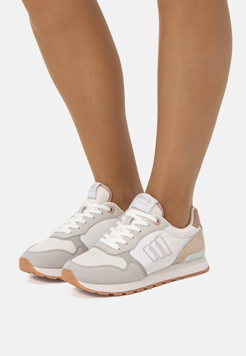 Sneakers bianche e grigie con un design testurizzato, caratterizzate da un accento rosa chiaro, lacci bianchi e suola in gomma marrone.