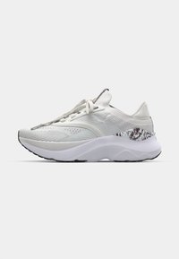 Baskets blanches avec un dessus texturé, un bout arrondi et une semelle rembourrée. Présente un accent à motif près du talon et des lacets plats.