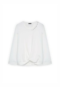 Maglietta bianca a maniche lunghe con scollatura rotonda e dettaglio anteriore annodato. Presenta decorazioni in strass sui gomiti.