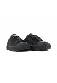 Sneakers neri con tomaia in pelle scamosciata, suola in gomma testurizzata e lacci piatti. Caratterizzati da un motivo di battistrada geometrico e una sobria marca sulla linguetta.