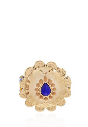Gold ring with scalloped edges featuring a central blue teardrop-shaped stone surrounded by smaller gold circles.