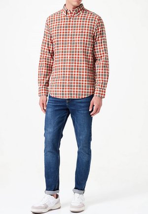 Rot-weißer kariert langer Ärmel Hemd mit Button-Down-Kragen, kombiniert mit blauen Jeans und weißen Sneakers. Legere Passform und Design.