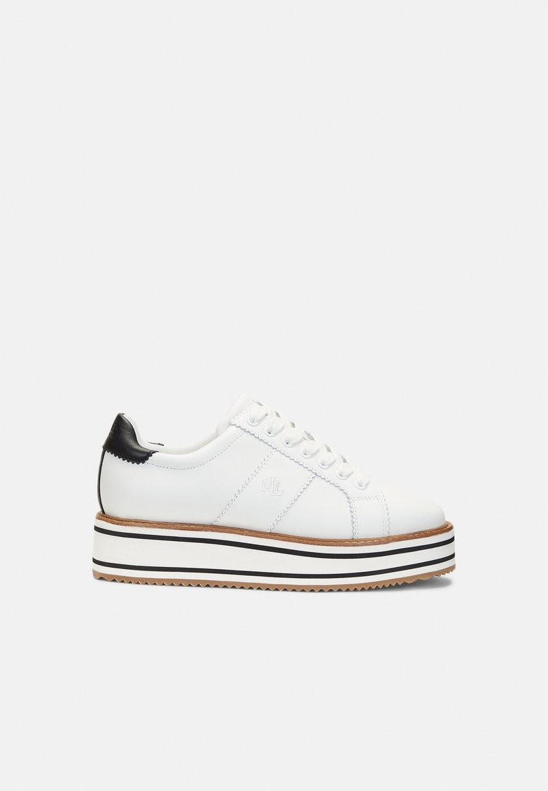 Baskets à plateforme blanches avec un accent noir au talon, fermeture à lacets à l'avant et semelle rayée en blanc, noir et beige sur un fond uni.