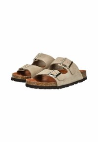Sandales en suède beige avec deux boucles métalliques réglables, semelle en liège et semelle en caoutchouc texturée. Design ouvert pour une meilleure ventilation.