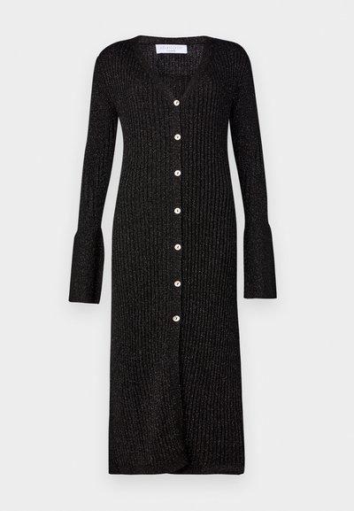 Mustlane ribakootud kardigan pikkade varrukatega, V-kaelusega ja nööpide sulgemisega ees. Omab laienevaid varrukaääreid ja õrna sära.