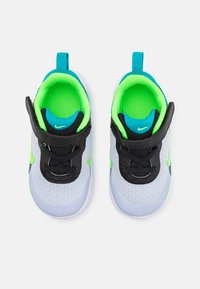 Graue Sportschuhe mit schwarzen Akzenten, grünem und blauem Innenleben, elastischen Schnürsenkeln und einem Klettverschluss; leichtgewichtige Mesh-Konstruktion.