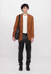 Brown suede blazer, white crew neck shirt, black leather pants, black sturdy boots, and a black messenger bag. Simple, tailored design.