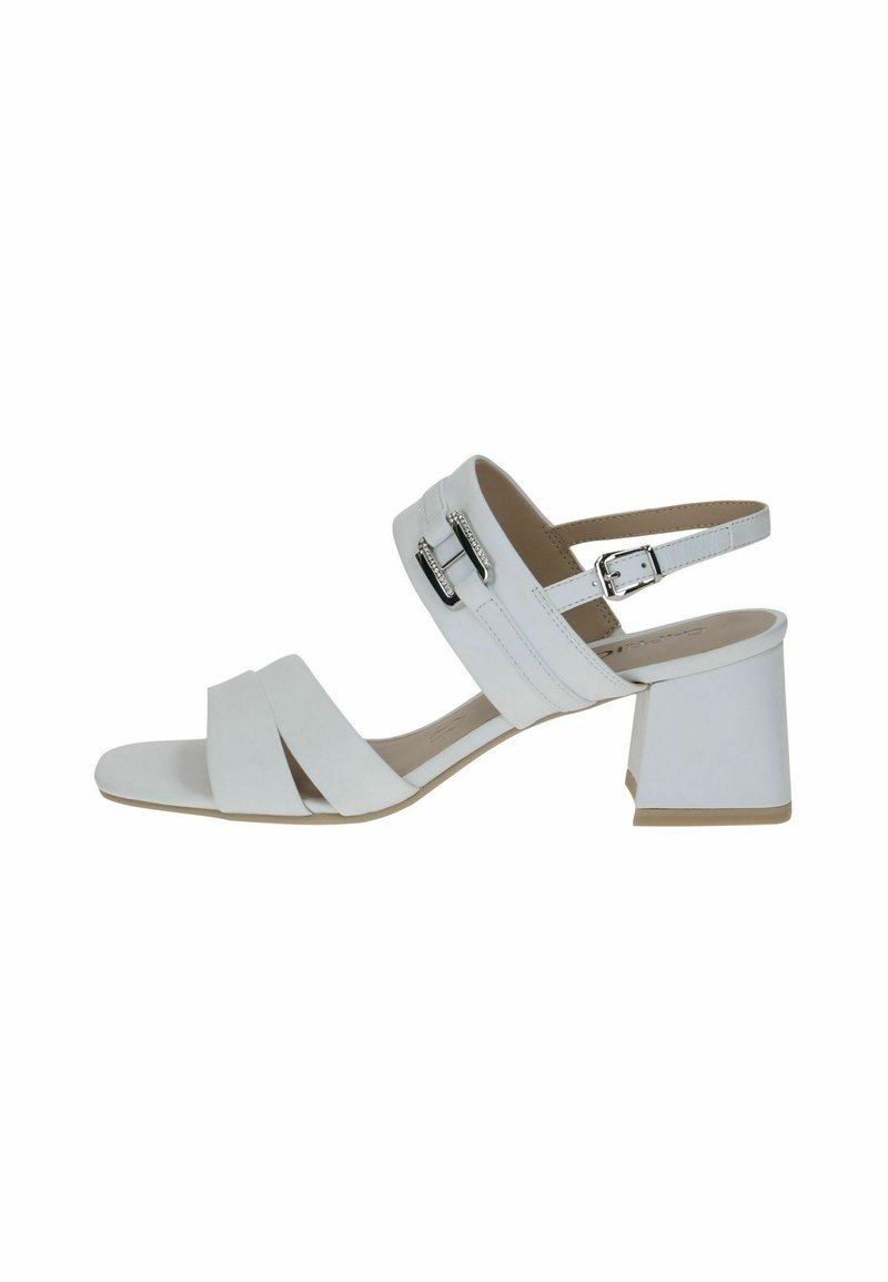 Valkoinen korkokenkä, jossa on lohkareempi korko, ristiin menevät hihnat, säädettävä nilkkaketju ja metallinen solkiyksityiskohta. Sujuva pinta, minimalistinen muotoilu.