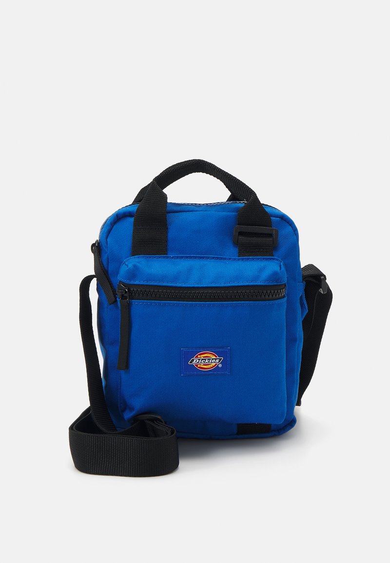 Bolsa cruzada de tecido azul com alça de ombro preta, alças superiores, bolso frontal com fecho e logótipo. Design compacto em forma de quadrado.