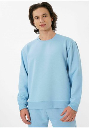 Light blue sweatshirt made from soft fabric. Features a crew neck, ribbed cuffs, and a relaxed fit. Accompanied by matching bottoms.