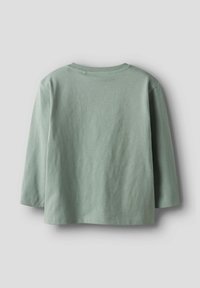 Svaigi zaļa garām piedurknēm T-krekls, izgatavots no mīksta kokvilnas. Vienkāršs dizains ar apaļu kakla izgriezumu un brīvu piegriezumu.