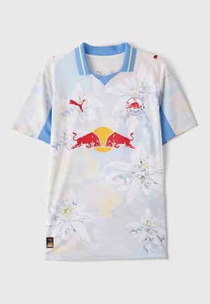 Camiseta de manga corta en azul claro y blanco con patrones florales, que presenta logotipos rojos y un cuello en V. Fabricada con material que absorbe la humedad.