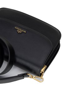 Schwarze Handtasche aus Leder mit strukturiertem Design, ausgestattet mit goldenen Hardware-Details und einem abnehmbaren Tragriemen für Vielseitigkeit.