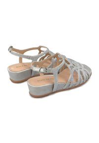 Srebrne sandały na wedge z krzyżującymi się paskami, z metalicznymi akcentami i gładkim, błyszczącym materiałem wierzchnim.