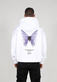White hoodie featuring a large purple butterfly graphic and black logo on the back, designed with a drawstring hood and elastic cuffs.