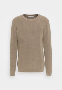 Pull en tricot beige avec une texture côtelée, col rond et manches longues. Il présente des poignets et un ourlet ajustés, offrant une silhouette structurée.