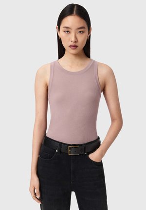 Débardeur mauve pâle à texture côtelée, col rond, associé à un jean noir taille haute et une ceinture noire avec une boucle dorée.