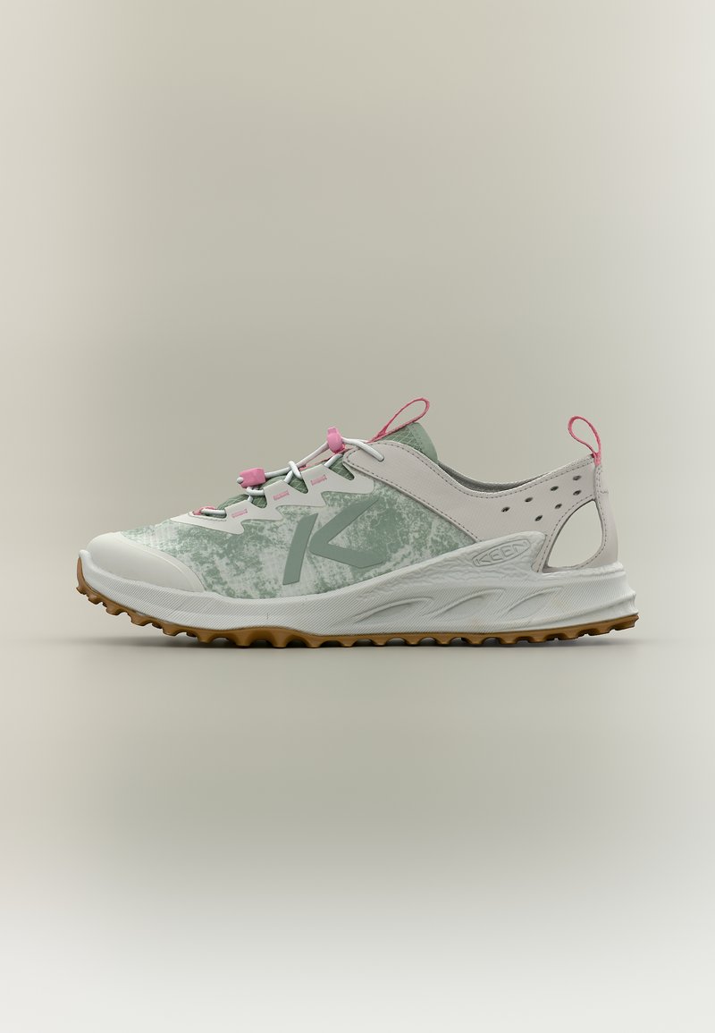 Αθλητικό παπούτσι ανοιχτού πράσινου και λευκού με ροζ λουράκια, υφή στη σόλα και σύστημα κορδονιών σχεδιασμένο για χρήση σε εξωτερικά μονοπάτια, παρουσιάζεται σε ουδέτερο φόντο.
