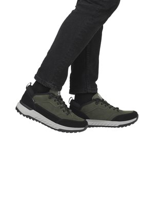 Chaussures de randonnée vertes avec accents noirs, tige en cuir suédé texturé et synthétique, semelle intermédiaire blanche robuste et motif de semelle agressif.