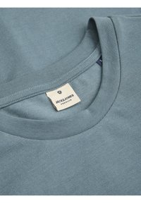 Lichtblauw T-shirt met ronde hals van gestructureerd materiaal, met een zichtbaar label waarop "JACK & JONES PREMIUM" staat.