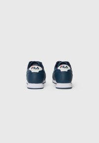 Marineblå treningssko med glatt skinnøvre, hvit såle og Fila-logo på hælen og tungen. Klassisk snøring-design, rund tå.