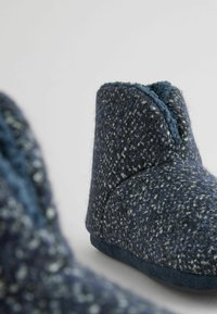 Chaussons en feutre bleu marine au fini texturé, dotés d'une doublure douce, d'un design à la cheville basse et d'une semelle plate de couleur unie.