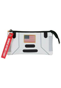 Funda blanca con cremallera que presenta una bandera estadounidense con bordes dorados, acentos negros y un llavero rojo con el texto "RETIRE ANTES DEL VUELO".