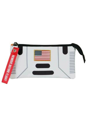 Funda blanca con cremallera que presenta una bandera estadounidense con bordes dorados, acentos negros y un llavero rojo con el texto "RETIRE ANTES DEL VUELO".