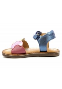 Sandalo per bambini con petali in pelle rosa e rossa, cinturino alla caviglia in metallo blu, soletta beige con un motivo floreale decorativo e suola in gomma.