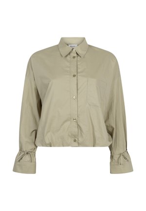 Beige cropped shirt met lange mouwen, puntige kraag, knopen aan de voorkant, borstzak en gestrikte manchetten op een witte achtergrond.