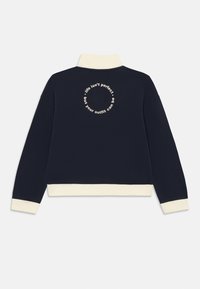 Marin sweatshirt med krämfärgad krage och manschetter, cirkulär krämfärgad text på baksidan som säger: "livet är inte perfekt, men din outfit kan vara."