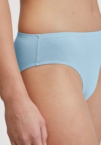 Hellblaue Baumwollunterhose mit glatter Textur, niedrigem Bund und Nahtdetails an den Seiten, im klassischen Briefschnitt.