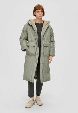 Padded long coat in light green with a fur-lined hood. Features two front pockets and snap button closure. Smooth texture and practical design.