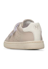 Basket en cuir beige avec un design perforé, accents blancs et fermeture velcro. Dispose d'une semelle en caoutchouc texturé et d'un bout rond.