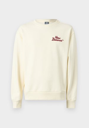 Φούτερ ανοιχτού κρεμ χρώματος με στρογγυλή λαιμόκοψη, μακριά μανίκια και μικρό κόκκινο λογότυπο «New Balance» στο αριστερό στήθος.